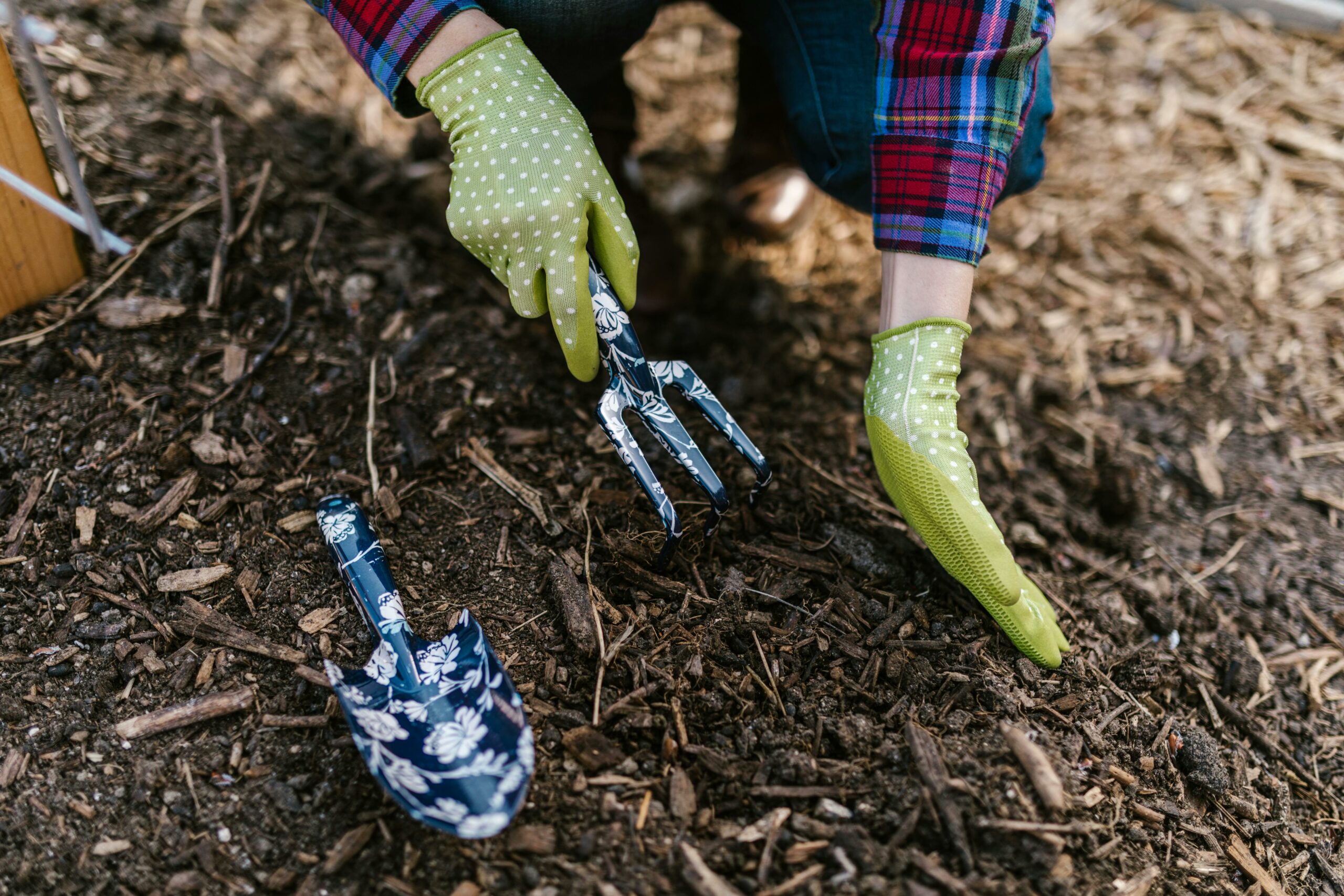 gloved hands using garden tools